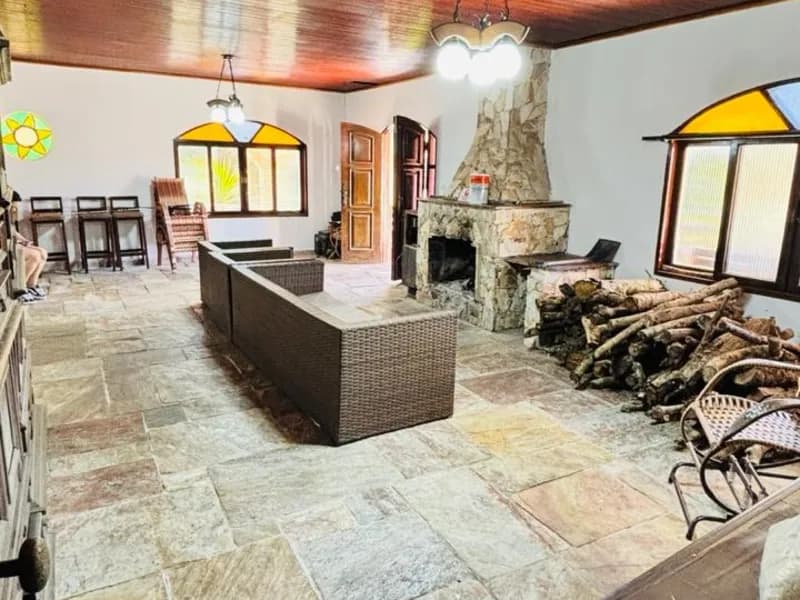 Lareira de pedra, lenha empilhada ao lado