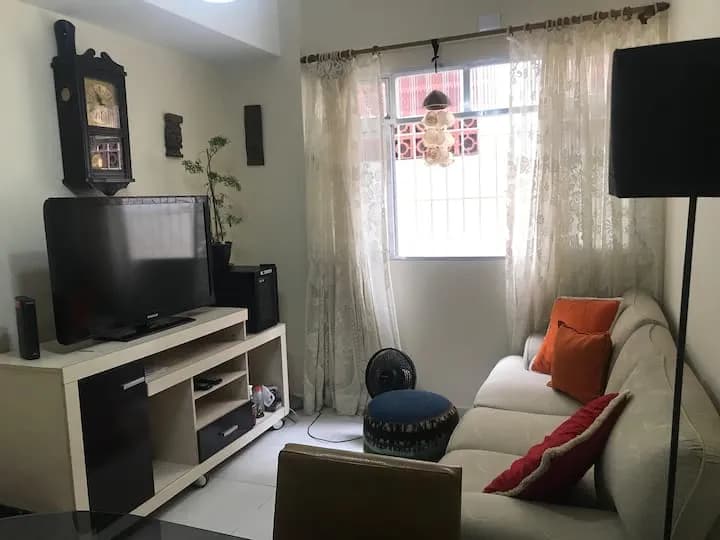 sala com TV, sofá e janela ampla