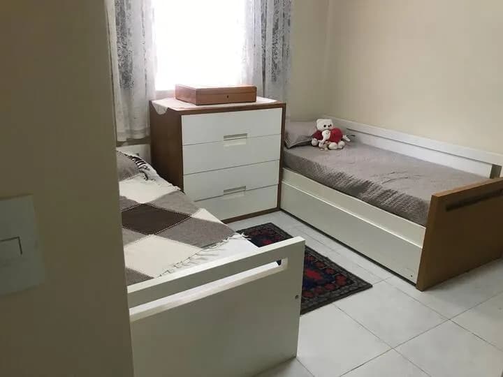 quarto com camas de solteiro e cômoda