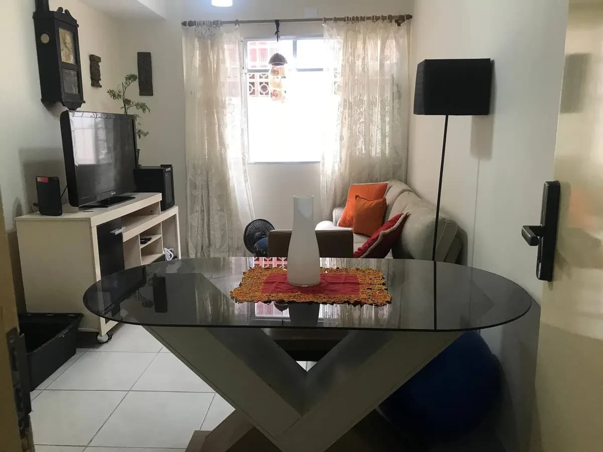 Sala de estar com mesa de jantar e sofá no apartamento térreo de Vila Tupi, Praia Grande