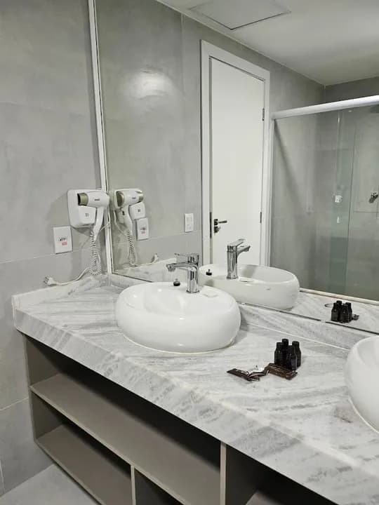 Banheiro com duas cubas e secador de cabelo