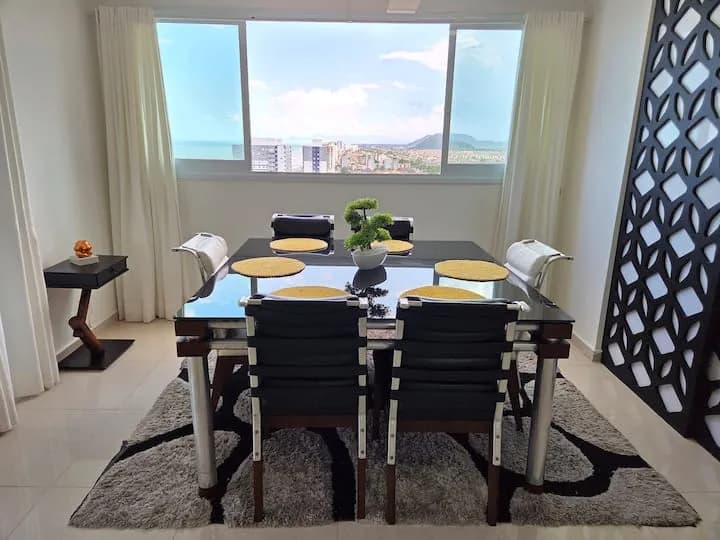 mesa de jantar junto ao janelão, mar ao fundo