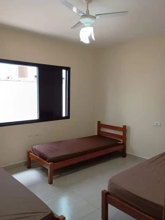 Quarto com camas de solteiro e ventilador