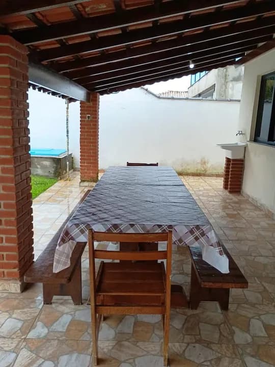 Pátio coberto com mesa e bancos