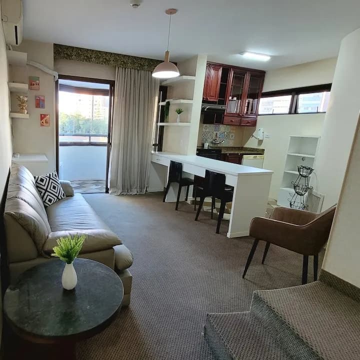 sala do flat com sofá e cozinha integrada