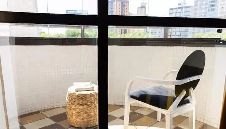 varanda privativa com mesa e vista dos prédios
