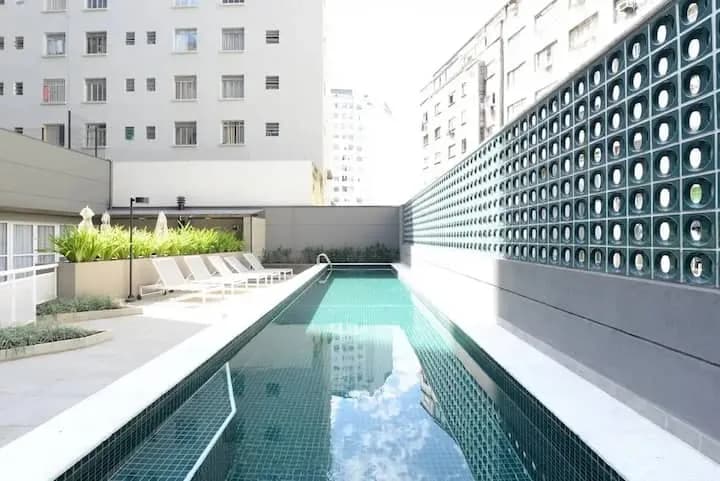 Piscina do condomínio com espreguiçadeiras
